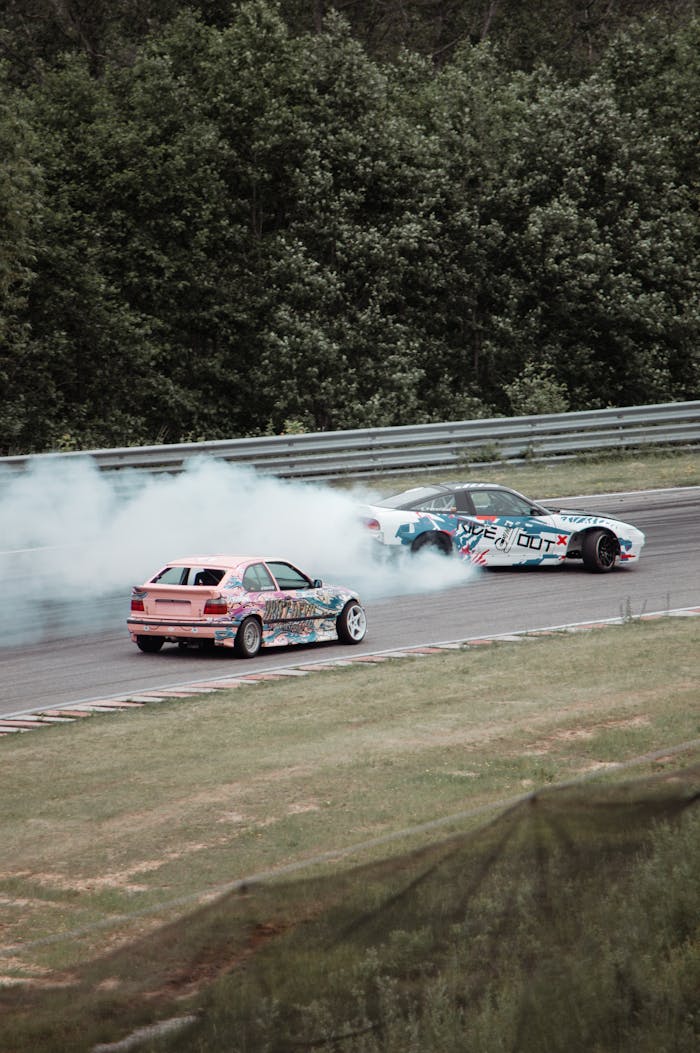 why-choose-us Exciting drifting scene featuring colorful cars creating smoke trails on a Lithuanian race track.