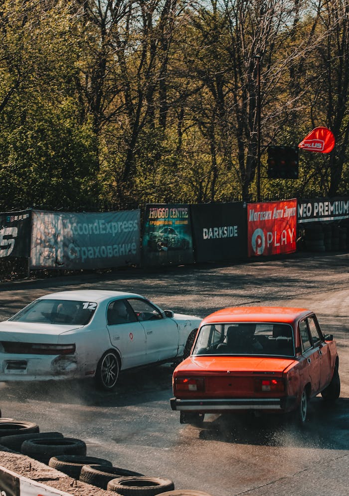 services-03 Dynamic drift competition featuring two cars racing on a sunny outdoor track with vibrant advertising banners.