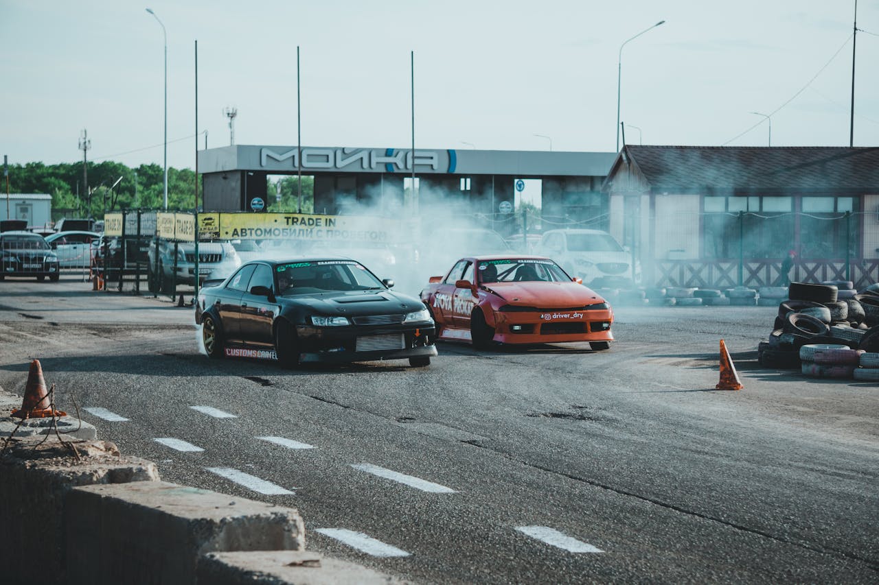 home-hero Two drift cars competing on a race track with smoke trails and speed.